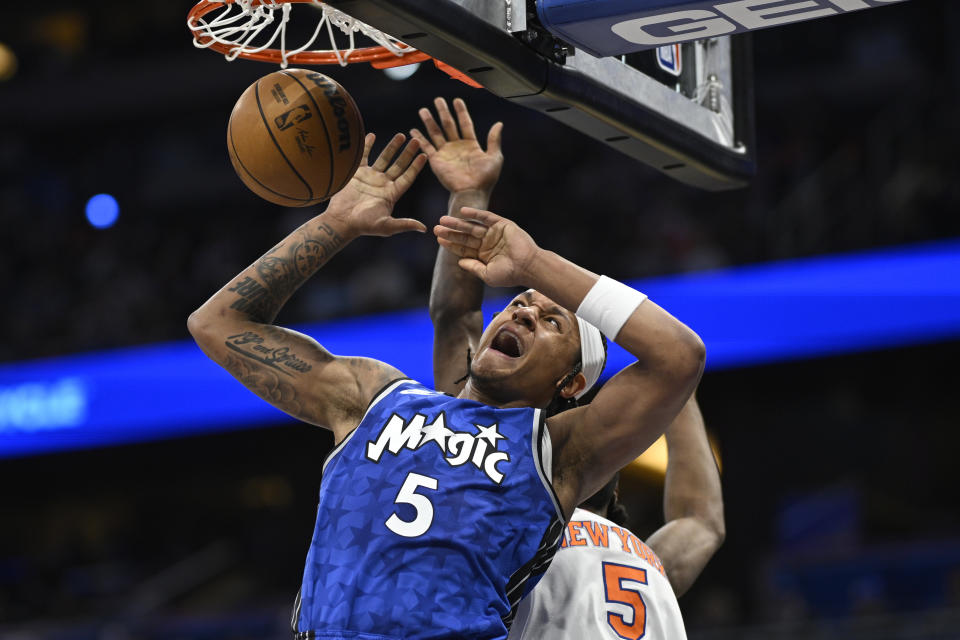 Orlando Magic forward Paolo Banchero dunks in front of New York Knicks forward Precious Achiuwa during the first half of an NBA basketball game Wednesday, Feb. 14, 2024, in Orlando, Fla. (AP Photo/Phelan M. Ebenhack)