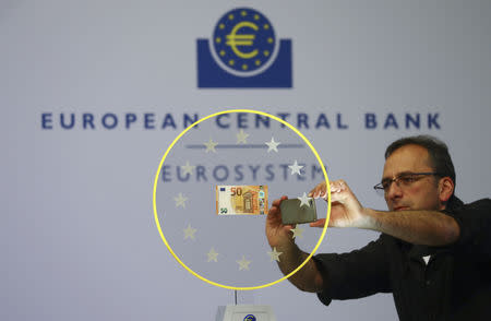 FILE PHOTO - A journalist takes a picture of the new 50 Euro banknote with a mobile phone during the presentation of the new bill at the European Central Bank (ECB) headquarters in Frankfurt April 4, 2017. REUTERS/Kai Pfaffenbach