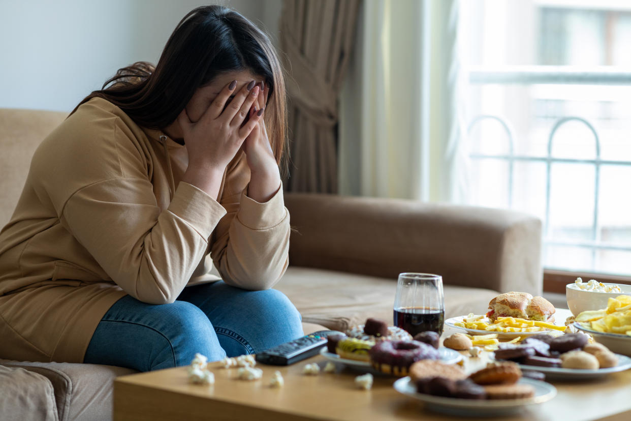 Unhappy stressed woman depicting food addiction 