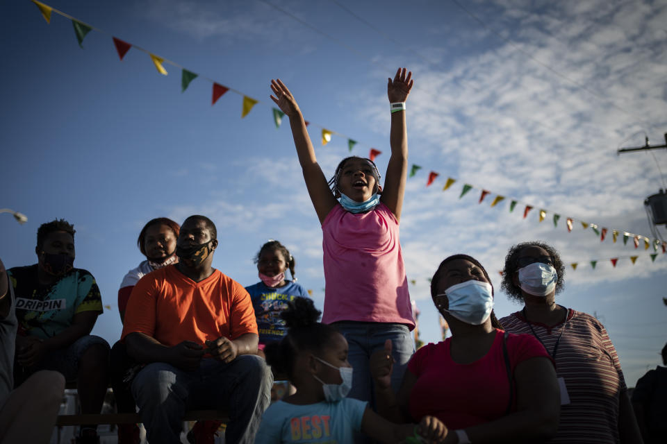 Ka'miyah Buck, 9, cheers while watching a pig race at the Mississippi State Fair, Wednesday, Oct. 7, 2020, in Jackson, Miss. The virus ripped through Mississippi's Black community early in the pandemic. About 60% of infections and deaths were among African Americans, who make up 38% of the state's population. (AP Photo/Wong Maye-E)