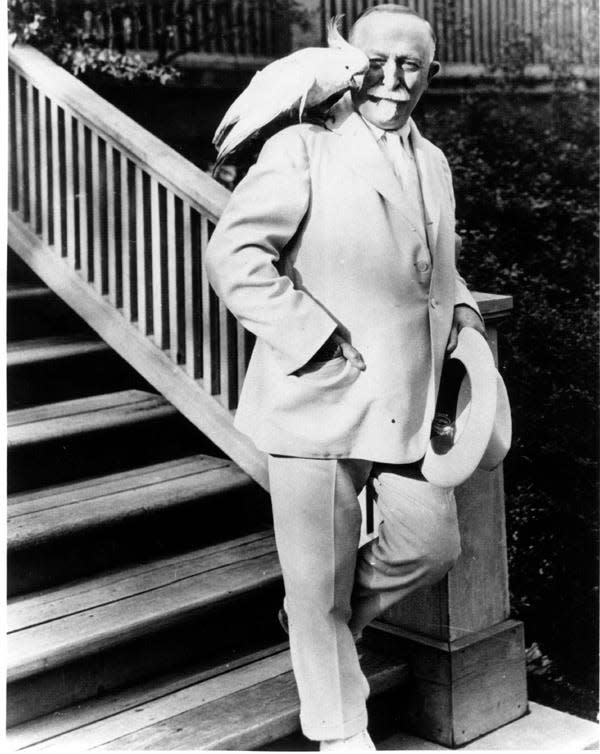 Dr. John Harvey Kellogg wearing his trademark all-white suit with his pet cockatoo on his shoulder.