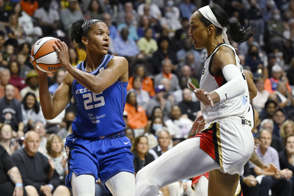 Connecticut Sun's Alyssa Thomas, left, looks to pass while Las Vegas Aces' A'ja Wilson defends during the first half in Game 3 of a WNBA basketball final playoff series, Thursday, Sept. 15, 2022, in Uncasville, Conn. (AP Photo/Jessica Hill)