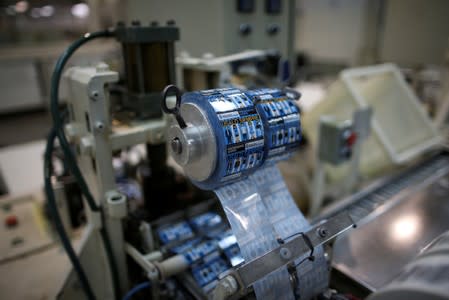 Condom packaging with words reading "always use it" is seen in a machine in a factory in Buenos Aires