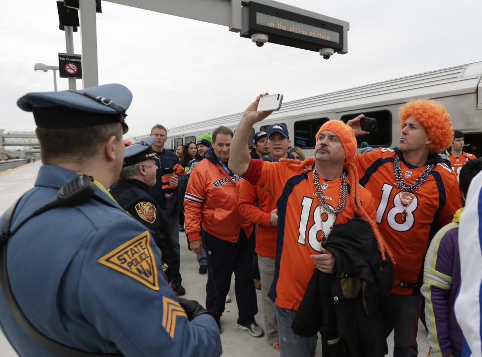 Denver Broncos fans take pictures of the stadium as they arrive at the Meadowlands Rail Station before the NFL Super Bowl XLVIII football game Sunday, Feb. 2, 2014, in East Rutherford, N.J. (AP Photo/Gregory Bull)