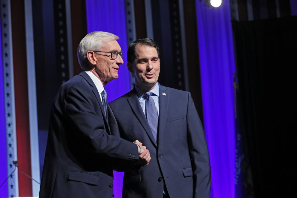 Democrat Tony Evers, left, and then-Gov. Scott Walker, a Republican, shake hands during a media event before the start of a 2018 gubernatorial debate.