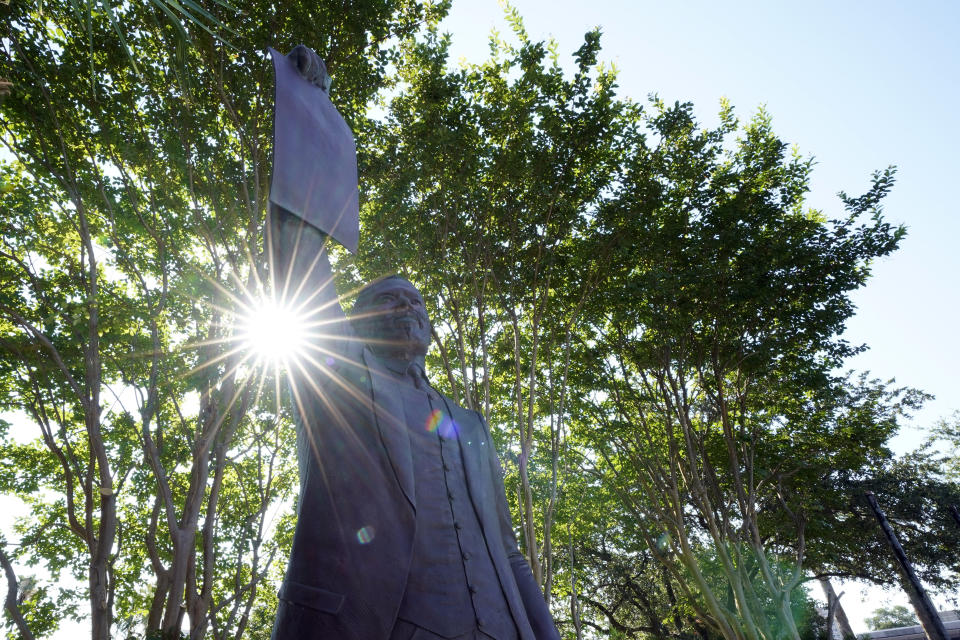 This June 17, 2020, photo, shows a statue depicting a man holding the state law that made Juneteenth a state holiday in Galveston, Texas. The inscription on the statue reads "On June 19, 1865, at the close of the Civil War, U.S. Army General Gordon Granger issued an order in Galveston stating that the 1863 Emancipation Proclamation was in effect. That event, later known as "Juneteenth," marked the end of slavery in Texas. Celebrated as a day of freedom since then, Juneteenth grew into an international commemoration and in 1979 became an official Texas holiday through the efforts of State Representative Albert (AL) Edwards of Houston." (AP Photo/David J. Phillip)