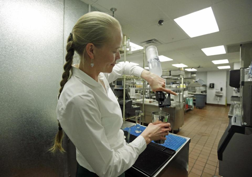 FILE - In this Feb. 26, 2013, file photo, manager Lindsay Pitts makes a mojito in the bar, which is beyond the view of patrons, in the kitchen of La Jolla Groves Restaurant, in Salt Lake City. The Mormon church has issued a sweeping defense of Utah's famously strict liquor laws, drawing a line against tourism, restaurant and bar industry advocates who have helped ease alcohol regulations in recent years. Ahead of the upcoming legislative session, The Church of Jesus Christ of Latter-day Saints posted to its website a hefty multimedia policy statement urging lawmakers to uphold rules that church leaders say are "closely tied to the moral culture of the state." (AP Photo/Rick Bowmer, File)