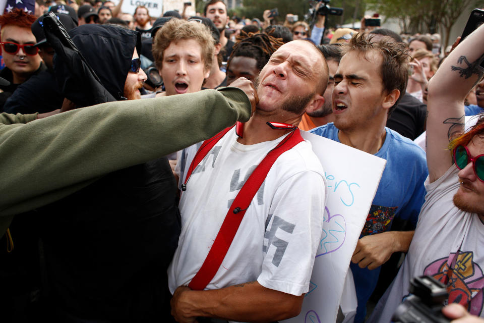 <p>OCT. 19, 2017 – A man wearing a shirt with swastikas on it is punched by an unidentified member of the crowd near the site of a planned speech by white nationalist Richard Spencer, who popularized the term ‘alt-right’, at the University of Florida campus in Gainesville, Florida. A state of emergency was declared on Monday by Florida Gov. Rick Scott to allow for increased law enforcement due to fears of violence. (Photo: Brian Blanco/Getty Images) </p>