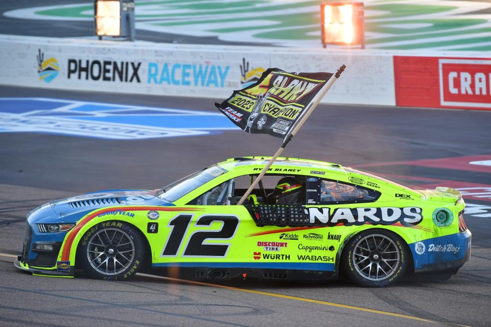 Ryan Blaney celebrates with the championship flag after capturing his first NASCAR Cup Series title, Sunday at Phoenix Raceway.