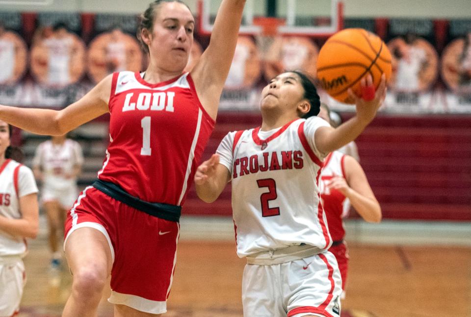 Lincoln's Riley Baquiran, right, drives to the hoop on Lodi's Kiah Aitken during a girls varsity basketball game at Lincoln High in Stockton on Jan. 25, 2024.