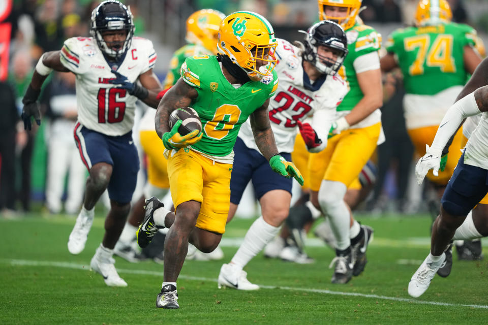 Jan. 1, 2024; Glendale, Arizona; Oregon Ducks running back Bucky Irving (0) runs the ball against the Liberty Flames during the second half in the 2024 Fiesta Bowl at State Farm Stadium. Joe Camporeale-USA TODAY Sports