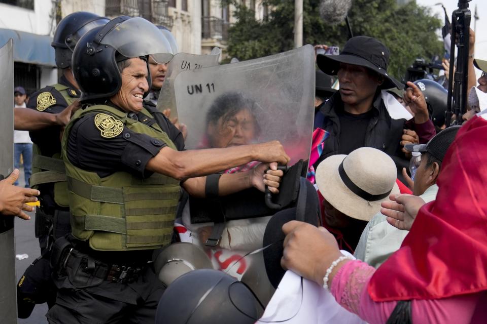 Anti-government protesters try to get past riot police blocking their path to the Palace of Justice during a demonstration marking International Workers' Day, in Lima, Peru, May 1, 2024. (AP Photo/Martin Mejia)