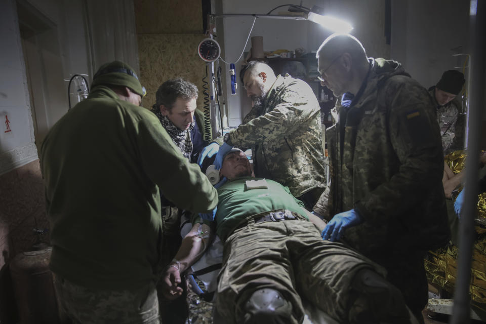 Medics give the first aid to a wounded Ukrainian soldier near Bakhmut, the site of the heaviest battles with the Russian troops, Donetsk region, Ukraine, Monday, Feb. 27, 2023. (AP Photo/Yevhen Titov)