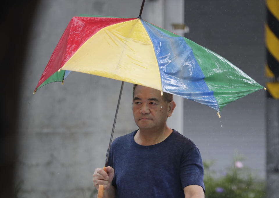 A man holds a ruined umbrella after struggling against gusts of wind generated by Typhoon Gaemi in Taipei, Taiwan, Wednesday, July 24, 2024. (AP Photo/Chiang Ying-ying)