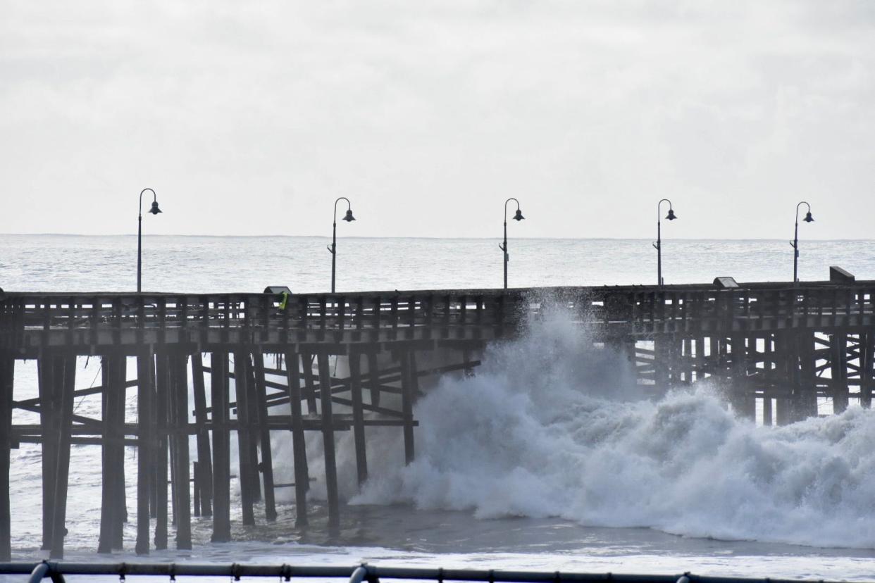 Waves roll under the Ventura Pier as high tide approaches on Saturday morning, Dec. 30, 2023.