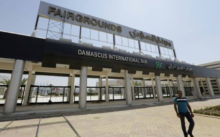 A picture taken on August 10, 2017, shows people walking past the grounds of the Damascus International Fair