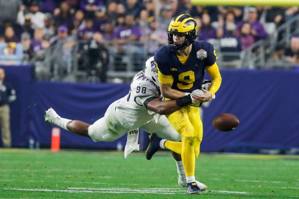 TCU defensive lineman Dylan Horton (98) knocks the ball out of the hands of Michigan quarterback J.J. McCarthy (9) during the first half at the Fiesta Bowl at State Farm Stadium in Glendale, Ariz. on Saturday, Dec. 31, 2022.