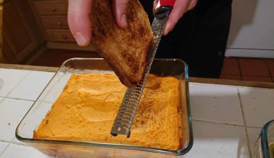 Grating a piece of toast.