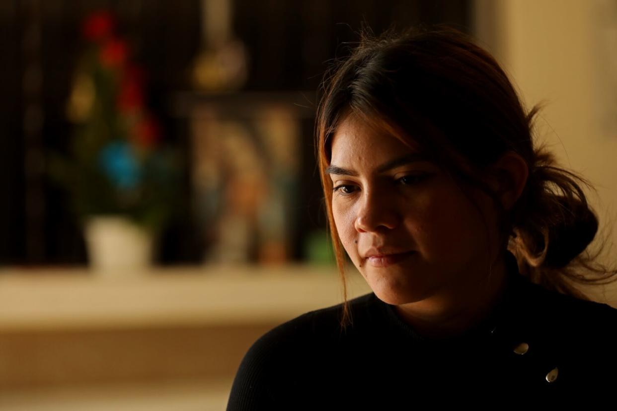 A closeup of a young woman in dim lighting