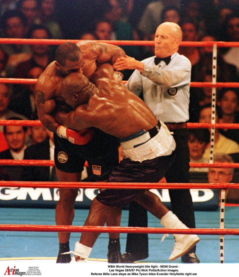 El árbitro intenta separar a Mike Tyson de la oreja de  Evander Holyfield. (Foto: Reuters)