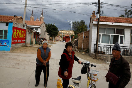 Villagers stand in a street near a Catholic underground church in the village of Huangtuang, Hebei province, China, September 30, 2018. REUTERS/Thomas Peter