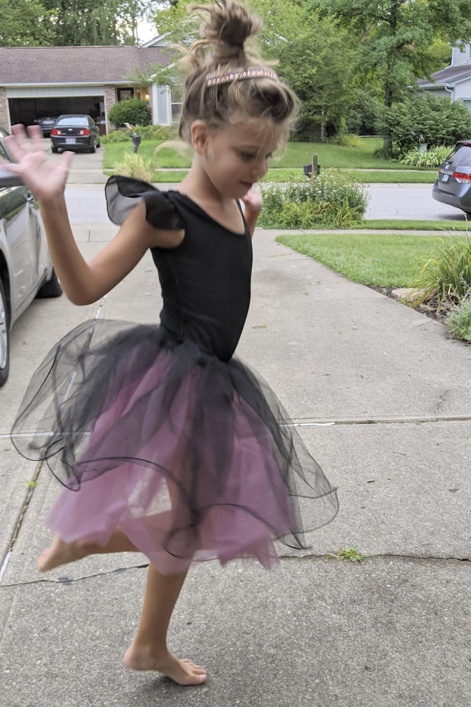 In this photo provided by courtesy of Nancy Peters, Margaret (Maggie) Hoying performs for her grandparents in the driveway after her dance recital which was cancelled due to the coronavirus, in August 2020, in Cincinnati. The pandemic and its isolating restrictions have been especially tough for many of the nation's some 70 million grandparents, many at ages when they are considered most vulnerable to the deadly COVID-19 virus. (Nancy Peters via AP)