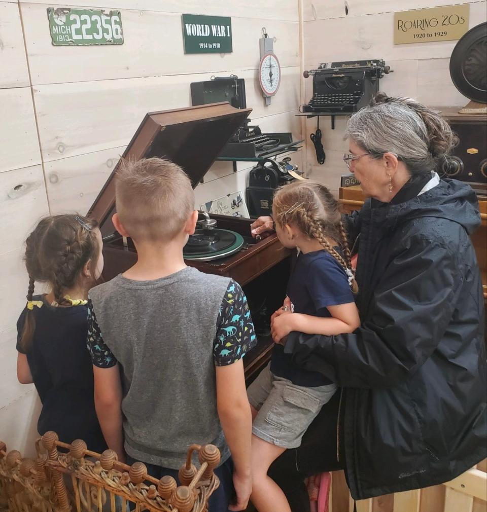 Cheri Leach and her grandchildren learn how to use a record player at the Raven Hill Discovery Center.