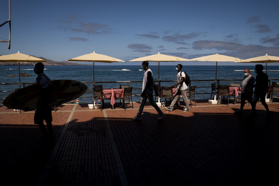 Asylum-seekers Kassim Diallo and Yamadou Konaré of Mali walk next to the beach in Las Palmas de Gran Canaria, Spain, on Thursday, Aug. 20, 2020. Kassim, 21, said “I risked my life like this because I was so sad. I have too many problems. But it’s not normal. A human being shouldn’t do this. But how else can we do it? It is tough there.” (AP Photo/Emilio Morenatti)