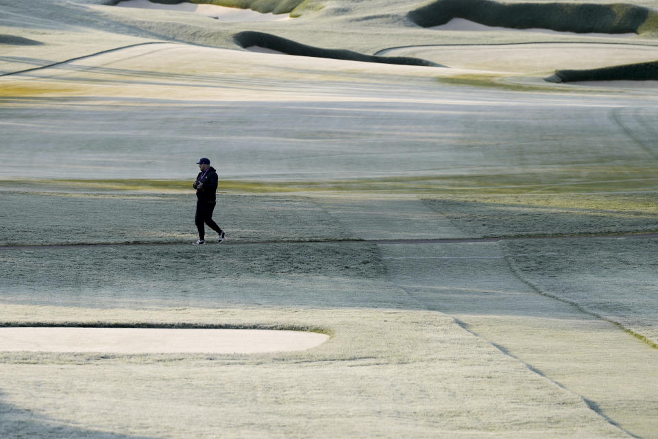 A worker walks the course during during a frost delay before the first round of the PGA Championship golf tournament at Oak Hill Country Club on Thursday, May 18, 2023, in Pittsford, N.Y. (AP Photo/Seth Wenig)