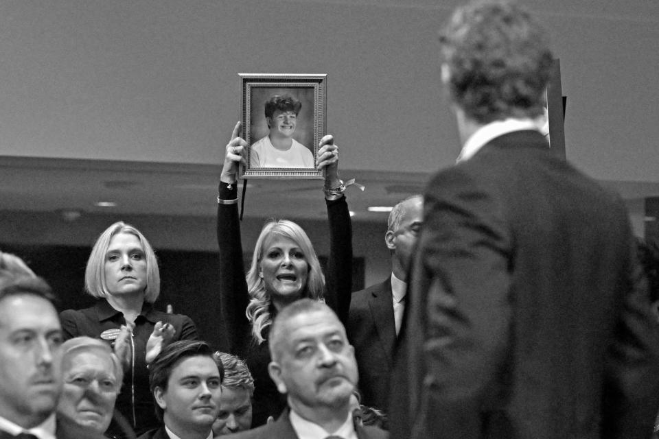 Jennie DeSerio with Mason's picture as Meta CEO Mark Zuckerberg speaks to victims and their family members as he testifies at a Senate Judiciary Committee hearing, 