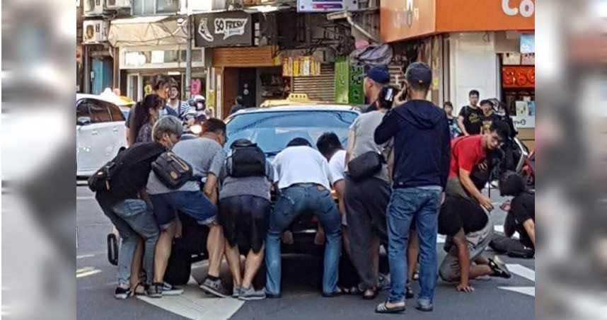 眾人合力抬車，將受困車底的小狗救出。（圖／翻攝自臉書社團基隆人）