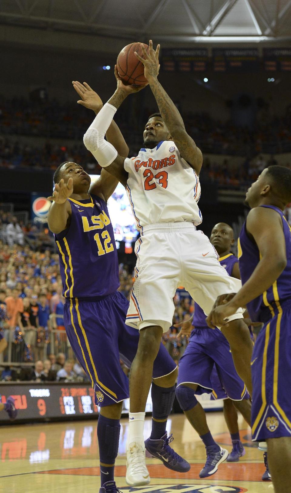 Florida's Chris Walker (23) goes for two points with LSU forward Jarell Martin (12) defending during the first half of an NCAA college basketball game on Saturday, March 1, 2014, in Gainesville, Fla. (AP Photo/Phil Sandlin)