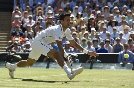 Novak Djokovic of Serbia hits a return during his men's singles semi-final tennis match against Grigor Dimitrov of Bulgaria at the Wimbledon Tennis Championships, in London July 4, 2014. REUTERS/Toby Melville