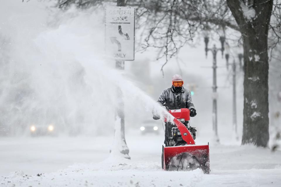 Ron Zeeb clears the snow from his property on Michigan Avenue on Friday, Dec. 23, 2022, in Lansing.