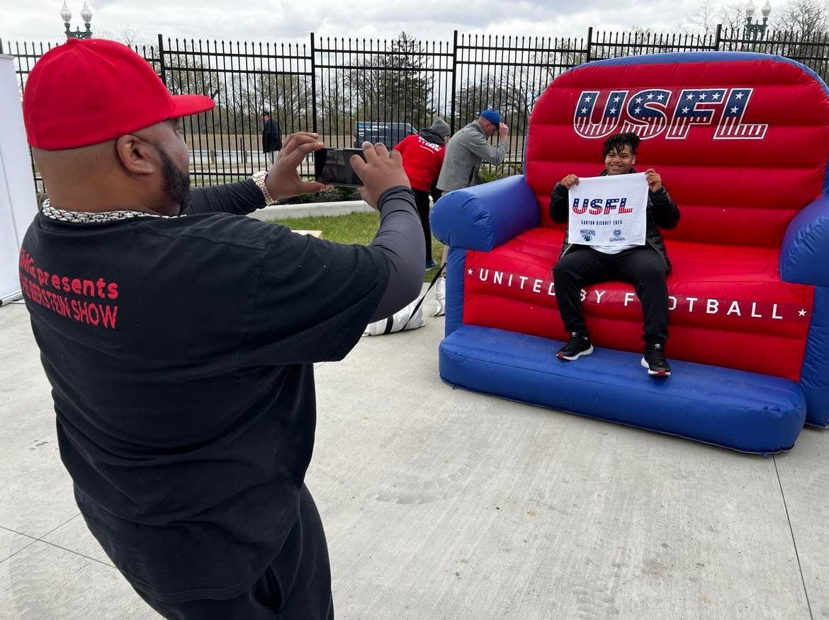 USFL fans take photos at a large inflatable chair Sunday at Tom Benson Hall of Fame Stadium in Canton. The New Jersey Generals defeated the Pittsburgh Maulers.