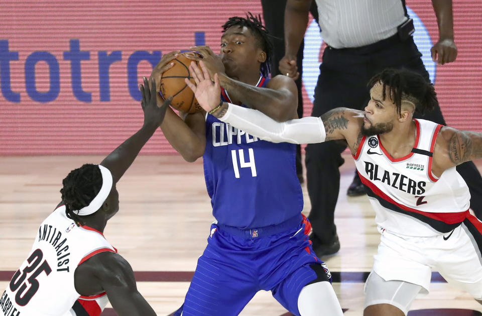 Los Angeles Clippers' Terance Mann (14) tries to control the ball as Portland Trail Blazers forward Wenyen Gabriel (35) and guard Gary Trent Jr. (2) defend during the second half in an NBA basketball game Saturday, Aug. 8, 2020, in Lake Buena Vista, Fla. (Kim Klement/Pool Photo via AP)