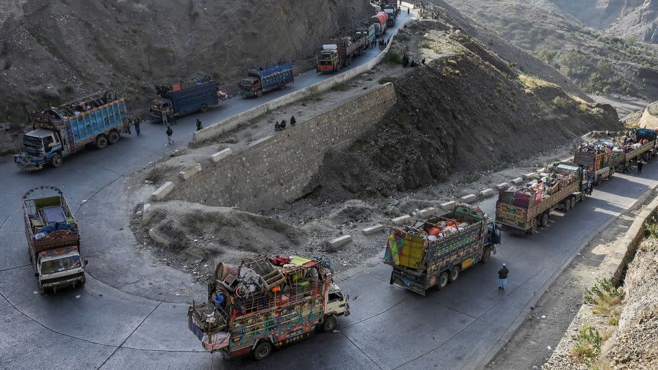 Trucks transporting Afghan refugees and their belongings are seen along a road heading toward the Pakistan-Afghanistan Torkham border on November 3, 2023. - Abdul Majeed/AFP/Getty Images