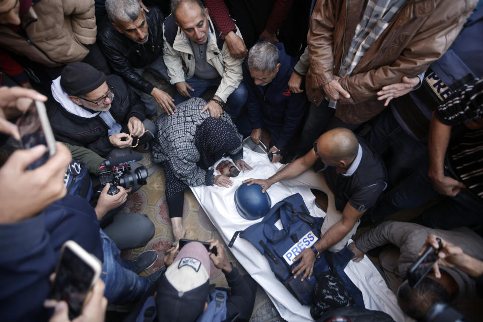 Relatives of the Al Jazeera cameraman, Samer Abu Daqqa, who was killed during an Israeli airstrike, mourn over his body, during his funeral in the town of Khan Younis, southern Gaza Strip. Saturday, Dec. 16, 2023. (AP Photo/Mohammed Dahman)