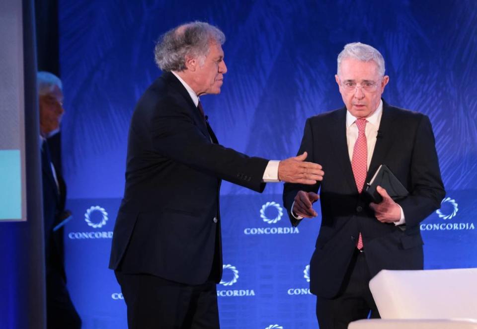 El Secretario General de la Organización de Estados Americanos, Luis Almagro, al centro, saluda a Álvaro Uribe Vélez, a la derecha, para iniciar la conversación sobre el futuro de la democracia en América Latina durante la Cumbre Concordia de las Américas en la Universidad de Miami el miércoles 13 de julio de 2019.