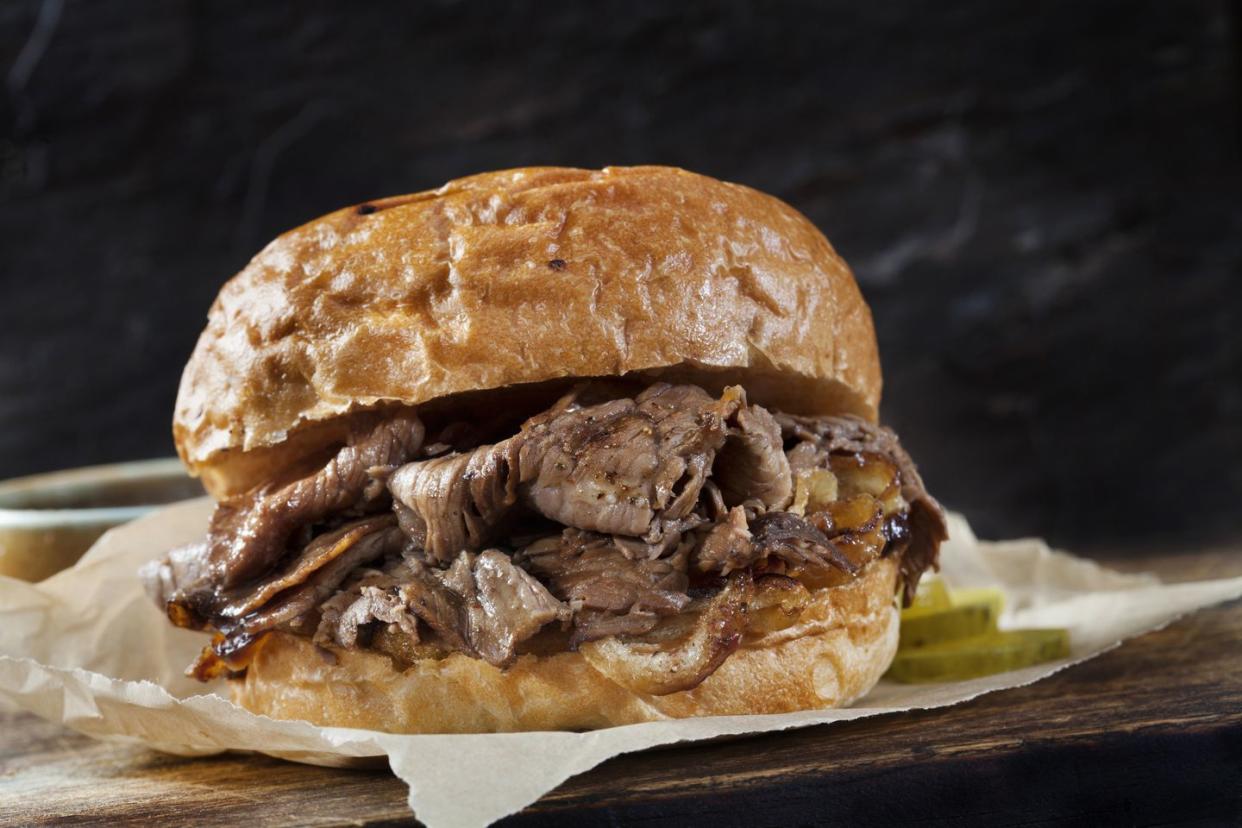 roast beef sandwich with au jus on a toasted onion bun