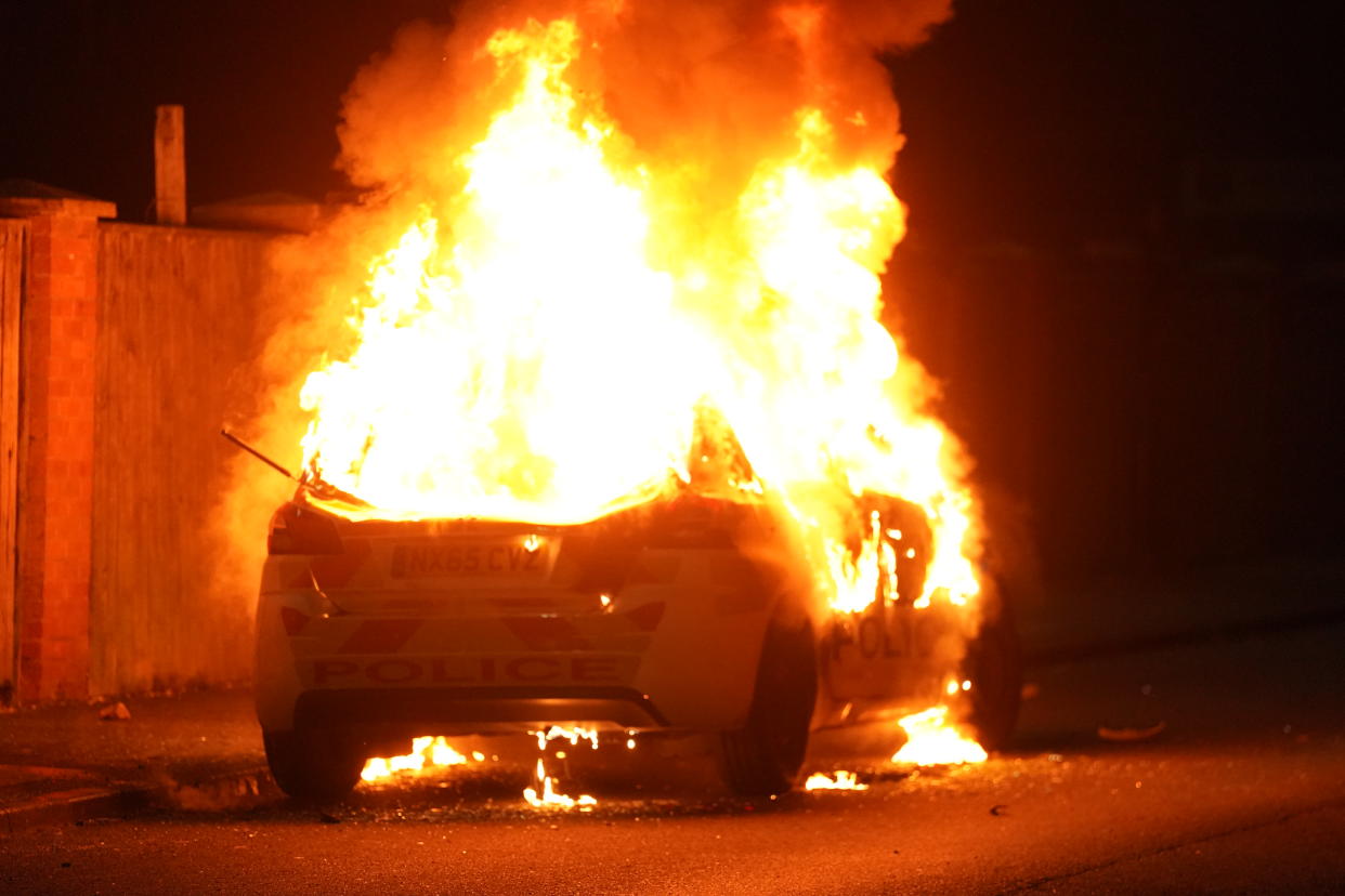 A police car burns in Hartlepool during the violent riots. (PA)