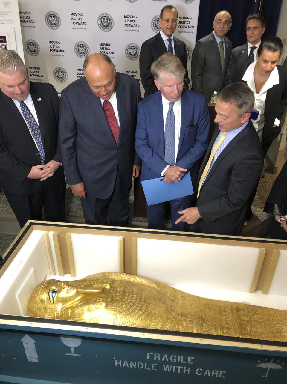 U.S. Homeland Security Investigations special-agent-in-charge Peter Fitzhugh, left, Egyptian Minister of Foreign Affairs Hassan Shoukry center left, Manhattan District Attorney Cyrus Vance Jr., center right and Assistant District Attorney Matthew Bogdanos view the Coffin of Nedjemankh at a repatriation ceremony in New York, Wednesday, Sept. 25, 2019. The coffin, featured at New York's Metropolitan Museum of Art until it was determined to be a looted antiquity, is on its way back to Egypt. (AP Photo/Michael R. Sisak)