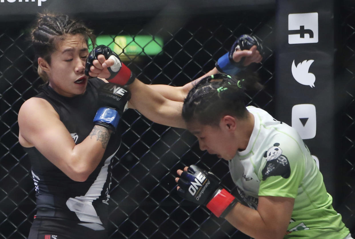 MMA fighters Angela Lee (left) and Xiong Jingnan trade punches during their ONE Championship bout in Tokyo in March 2019.