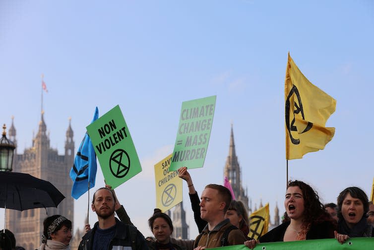 people with XR flags on a protest in London