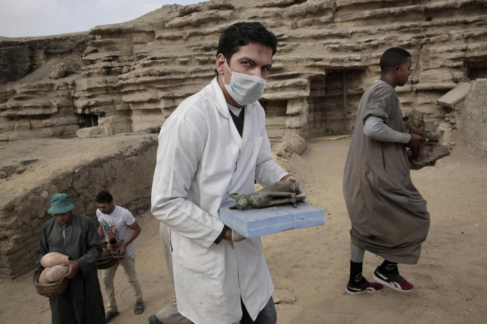 Un arqueológo trabaja en Egipto llevando artefactos encontrados en una tumba cerca de la antigua necrópolis en Saqqara. (AP Photo)