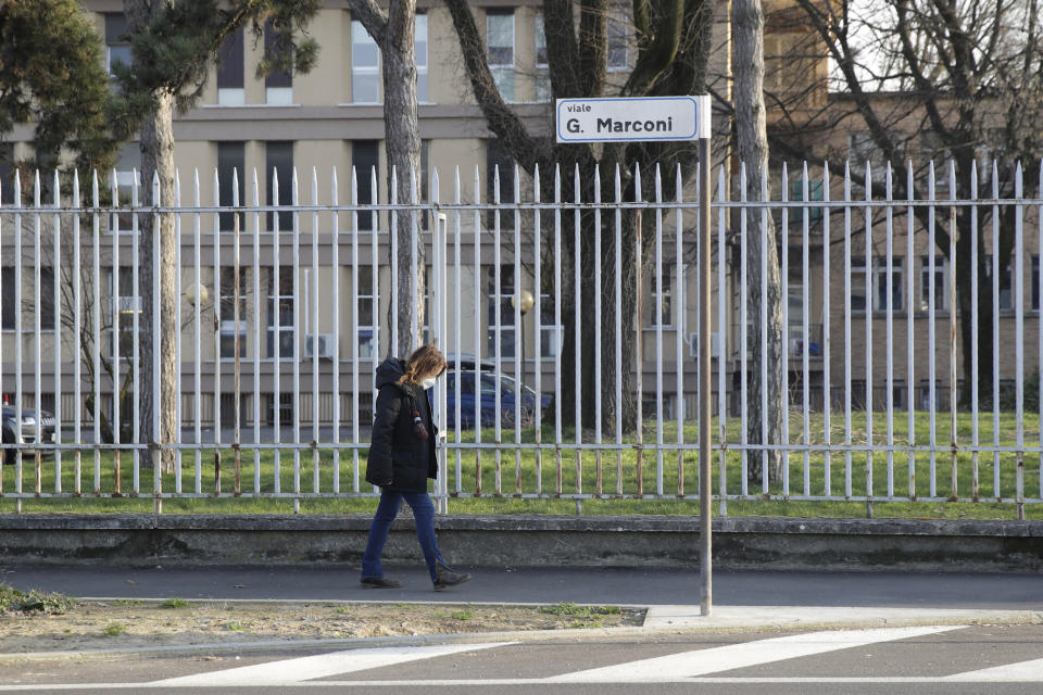 A woman wearing a sanitary mask walks in Codogno, near Lodi in Northern Italy, Friday, Feb. 21,2020. Health officials reported the country's first cases of contagion of COVID-19 in people who had not been in China. The hospital in Codogno is one of the hospitals - along with specialized Sacco Hospital in Milan - which is hosting the infected persons and the people that were in contact with them and are being isolated. (AP Photo/Luca Bruno)