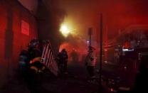 Baltimore firefighters rush ladders into position to fight fires in mutliple burning buildings set ablaze by rioters in Baltimore, Maryland April 27, 2015. REUTERS/Jim Bourg