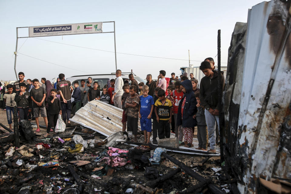 Palestinians look at the destruction after an Israeli strike where displaced people were staying in Rafah, Gaza Strip, Monday, May 27, 2024. Palestinian health workers said Israeli airstrikes killed at least 35 people in the area. Israel's army confirmed Sunday's strike and said it hit a Hamas installation and killed two senior Hamas militants. (AP Photo/Jehad Alshrafi)