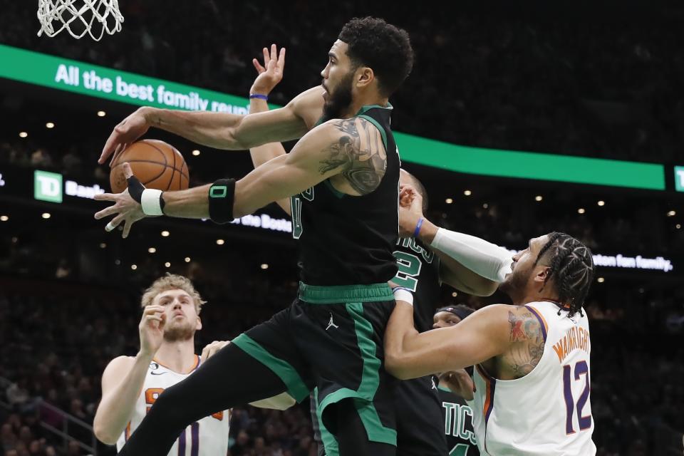 Boston Celtics' Jayson Tatum, center, battles Phoenix Suns' Ish Wainright (12) for a rebound during the second half of an NBA basketball game, Friday, Feb. 3, 2023, in Boston. (AP Photo/Michael Dwyer)