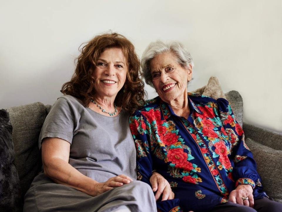 Daphna Able sits on a couch with her mother, Holocaust survivor Annetta Able, aged 99.